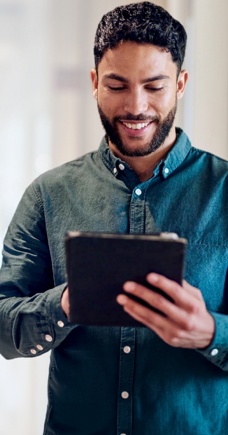 Person holding a tablet, standing against a plain background