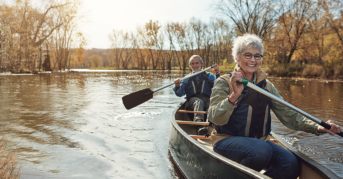 2 people rowing in a boat, enjoying retirement