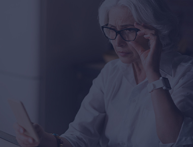 Woman adjusting glassing while looking at her phone
