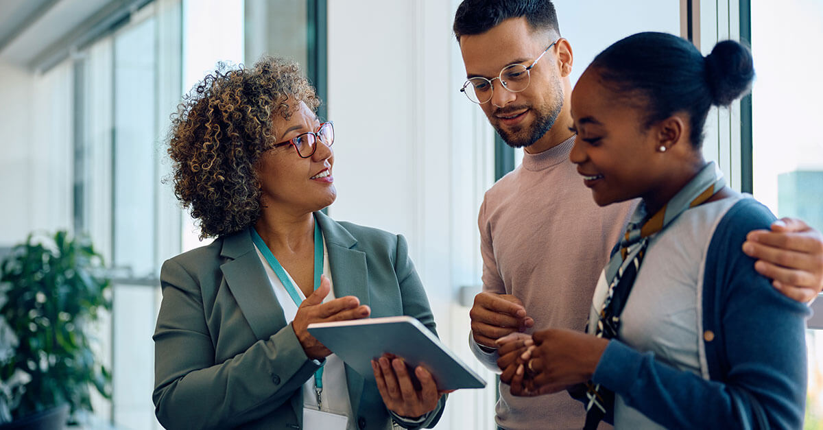 3 people looking at a tablet